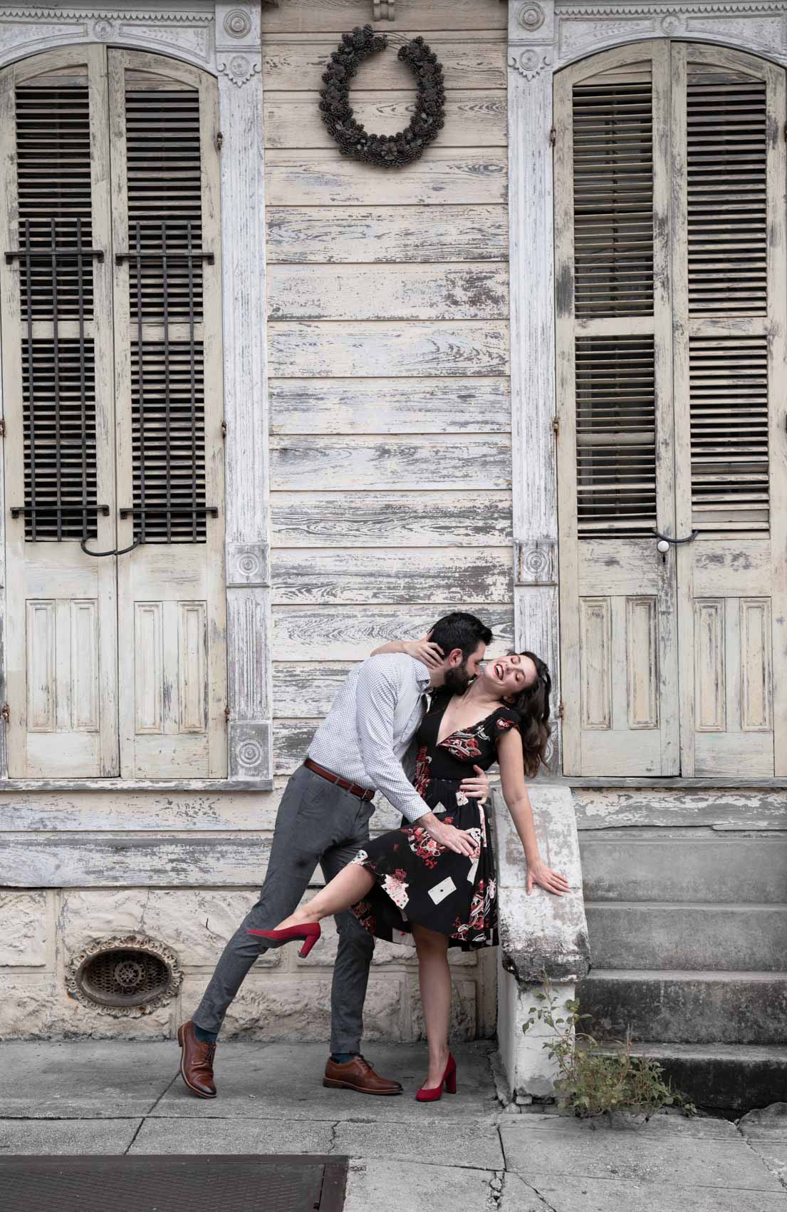 Couple kissing and dancing in the New Orleans French Quarter in front of old house