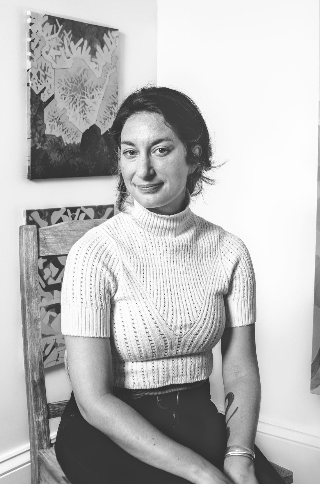 A female painter sitting in front of her art gallery in a New Orleans art studio