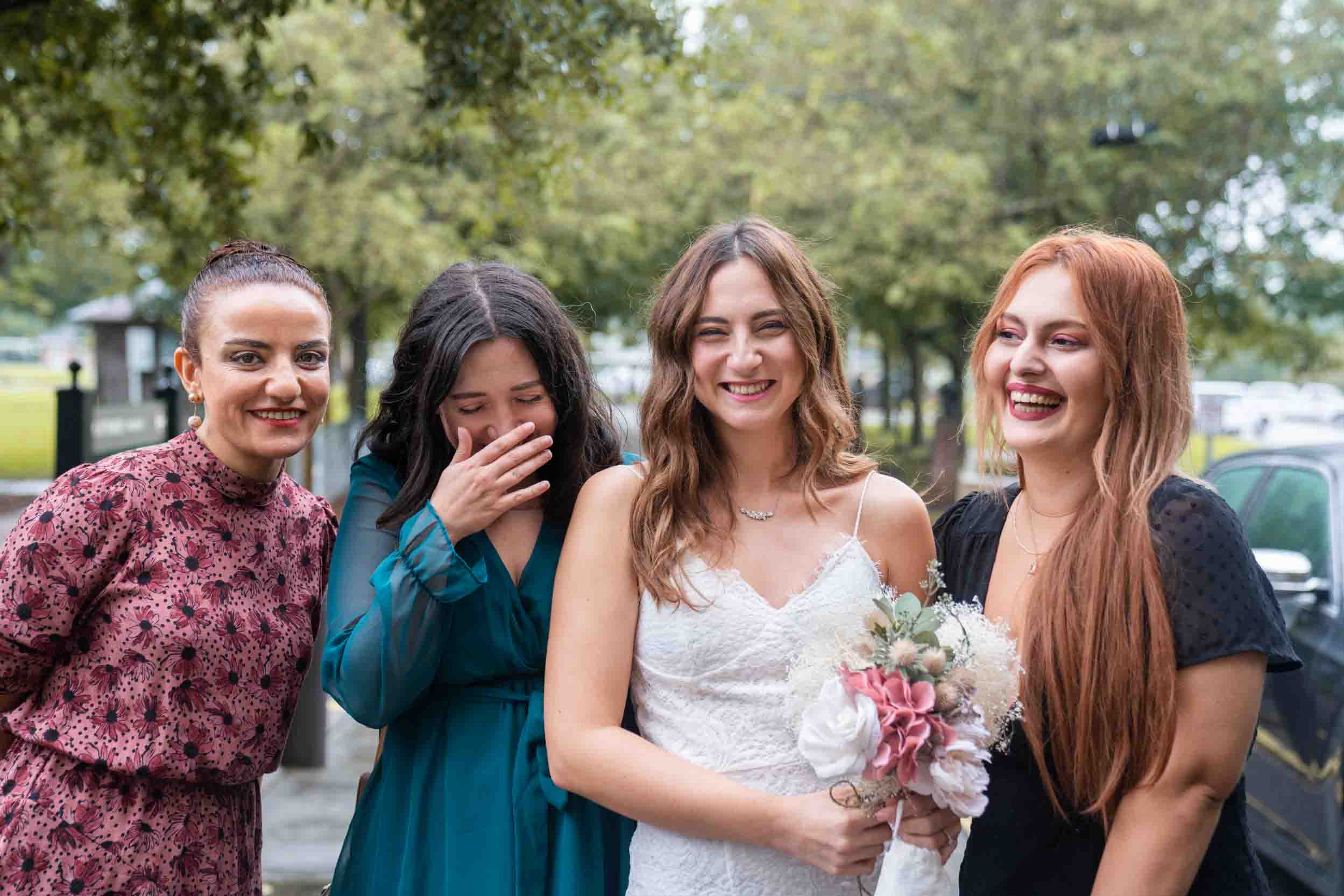 Bride and bridesmaids laughing together on wedding day