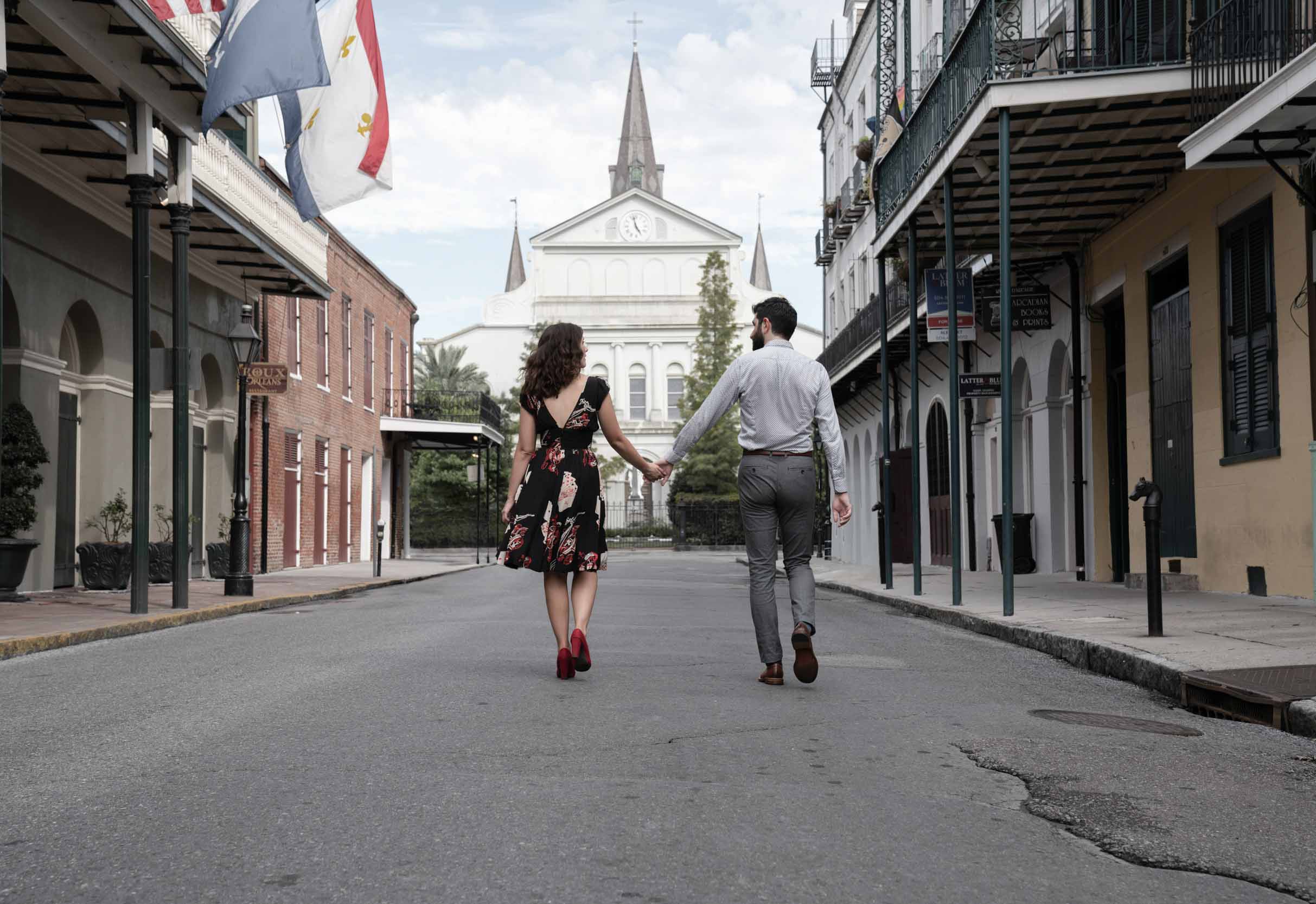 Romantic couple walking down Orleans Avenue in the New Orleans French Quarter holding hands