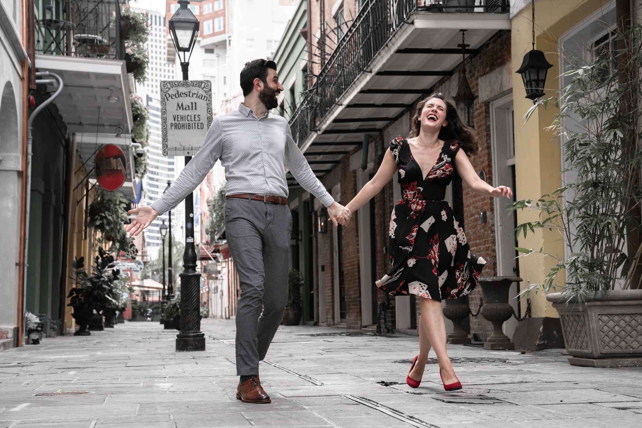 Romantic couple laughing and walking together in a New Orleans French Quarter alleyway