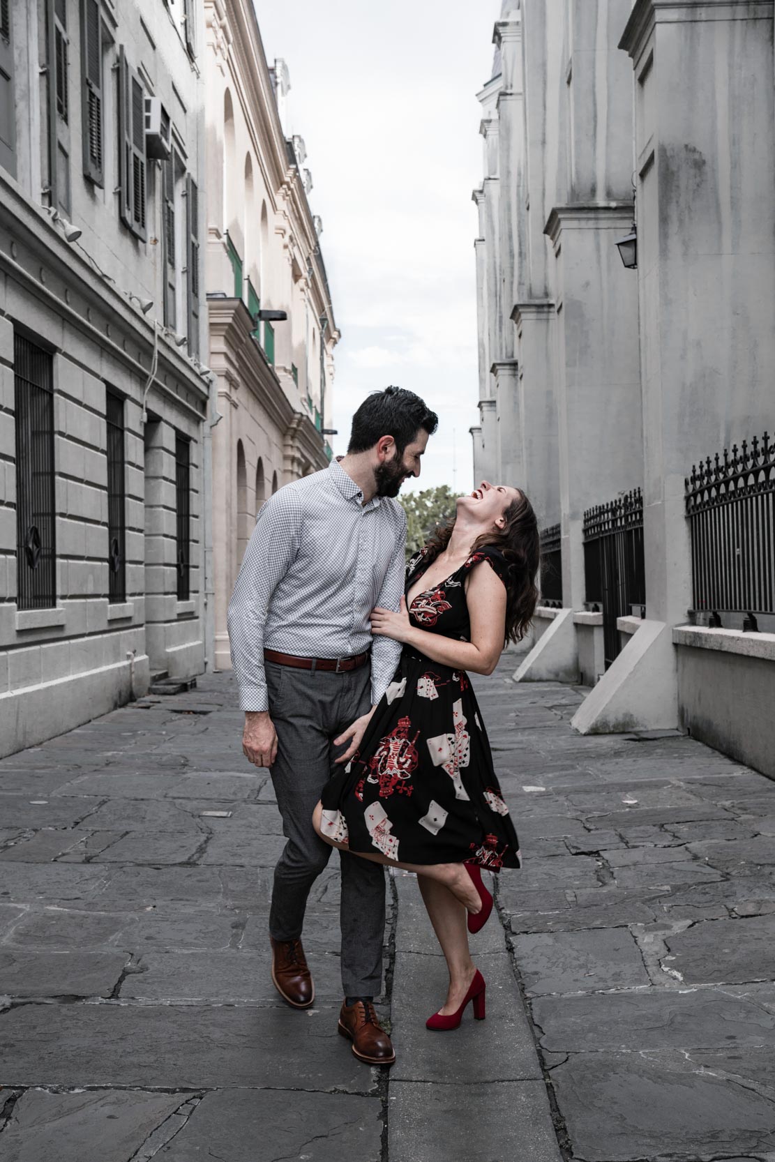 Romantic couple laughing together in front of French Quarter cathedral