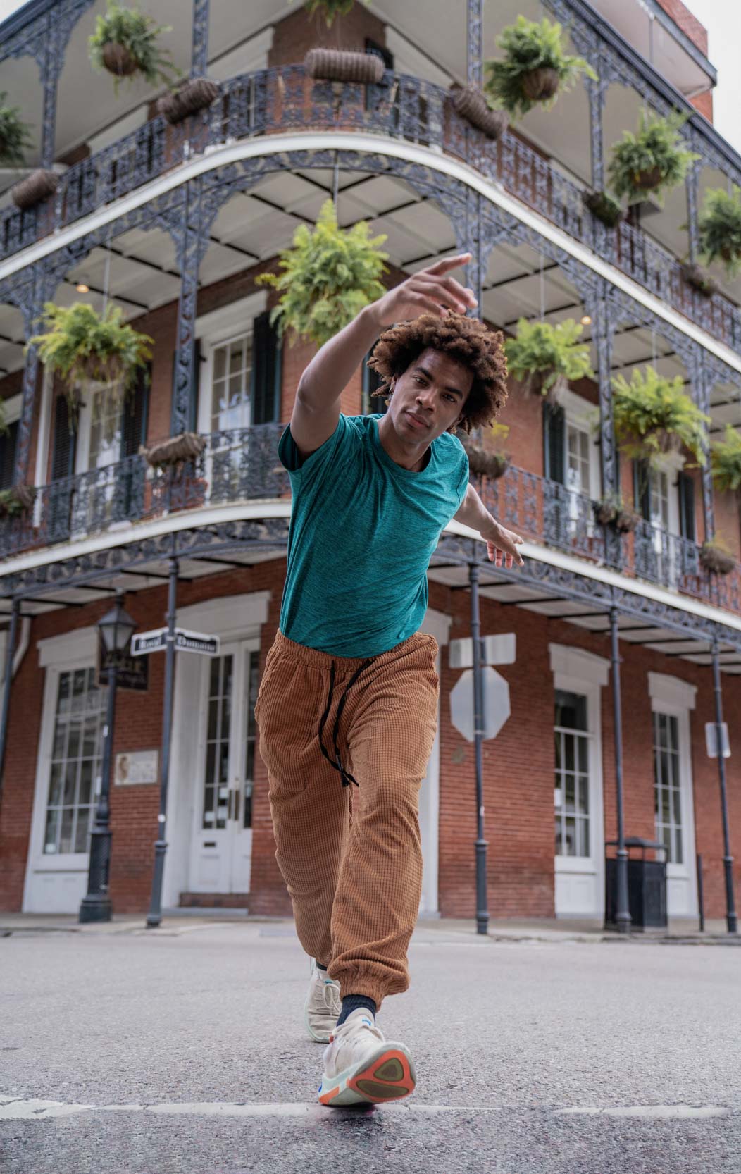A man walking and modeling for a dance shoot in the the New Orleans French Quarter