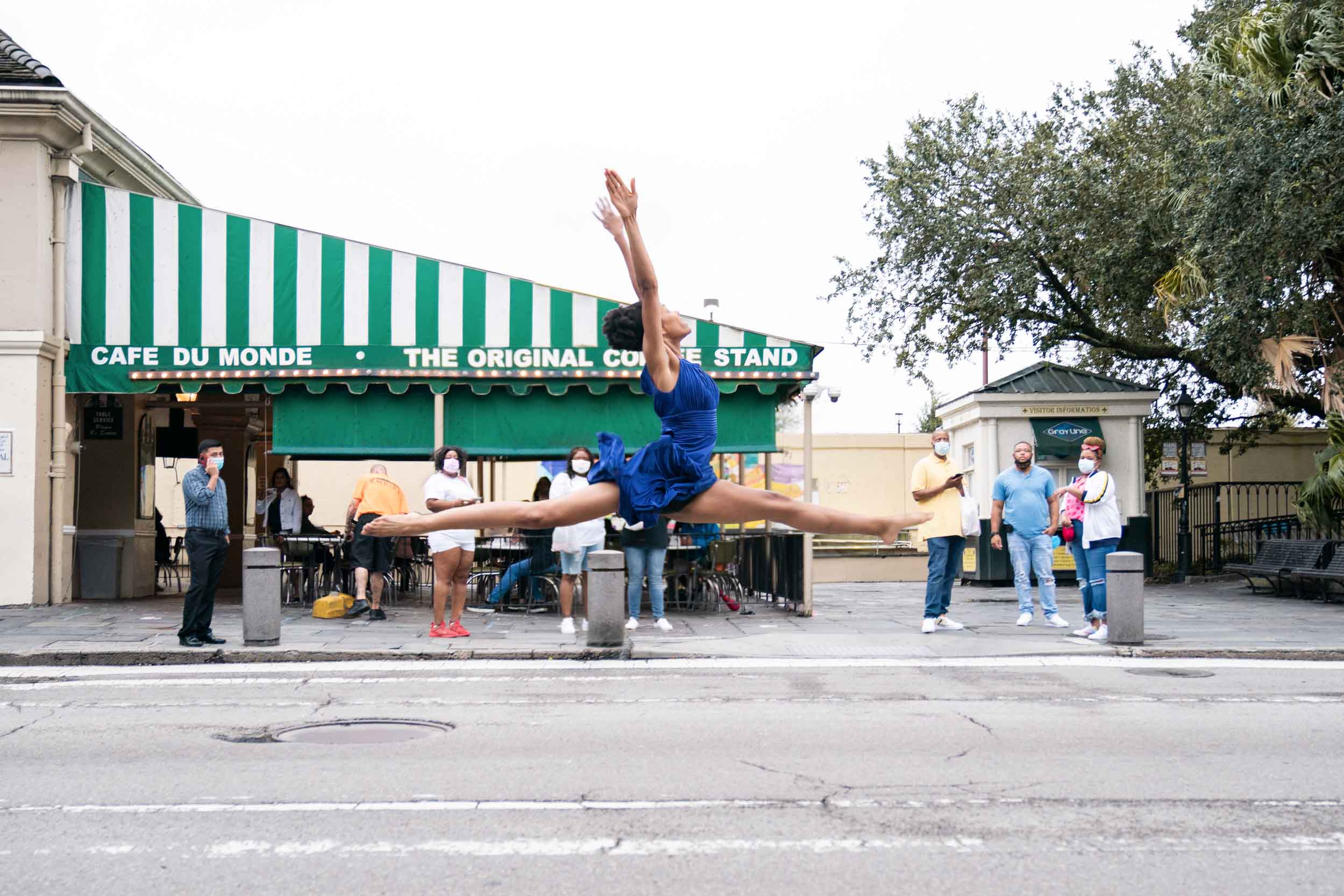 Female dancer performing epic jump in front of Cafe Du Monde in the New Orleans French Quarter