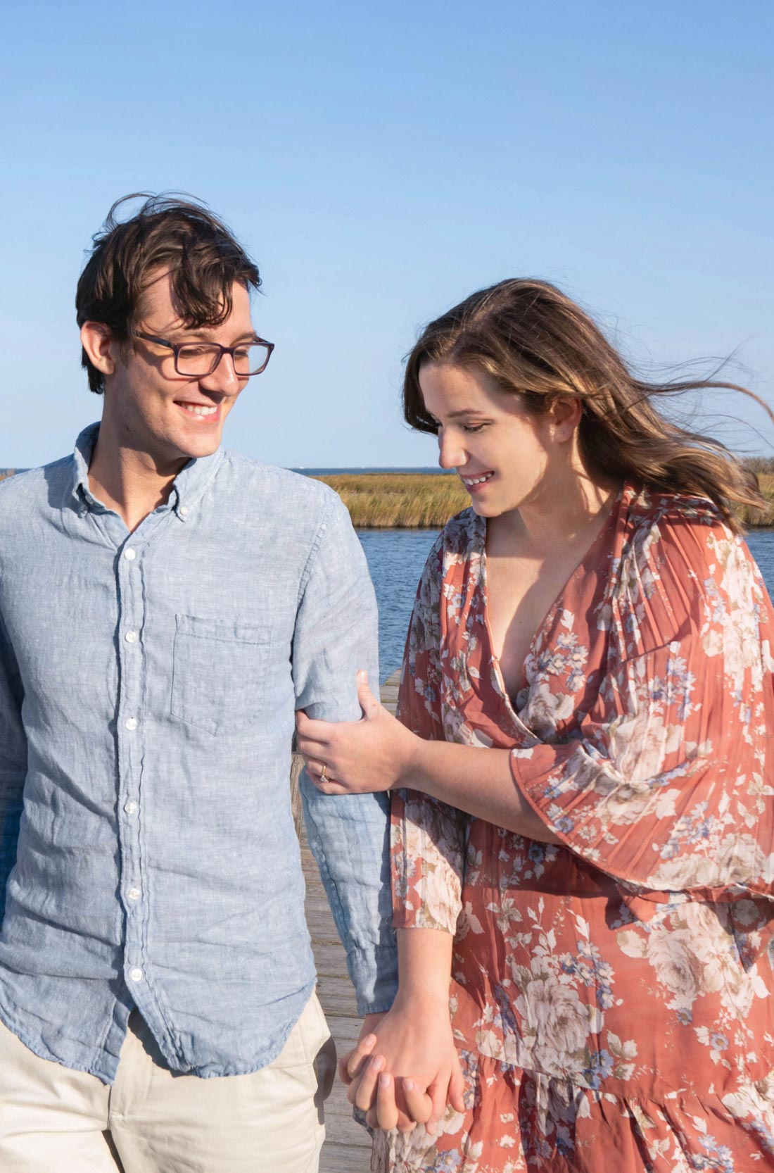 Couple walking together on a bayou dock in Louisiana after engagement proposal