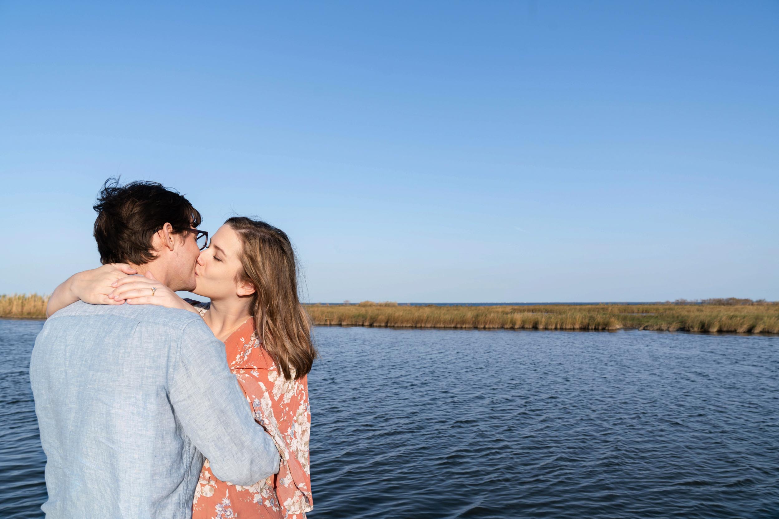 Engaged couple kissing along a bayou vista in Louisiana after engagment proposal