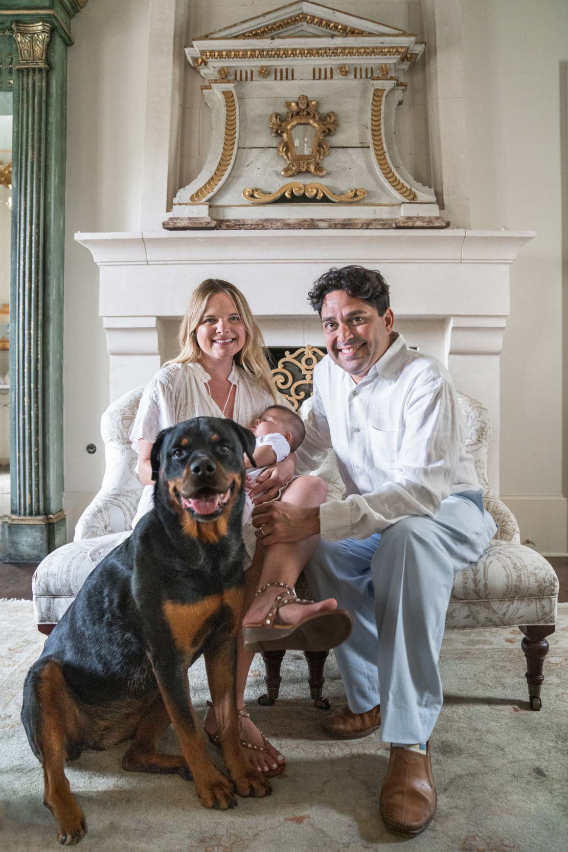 Family smiling with dog and baby in beautiful mansion