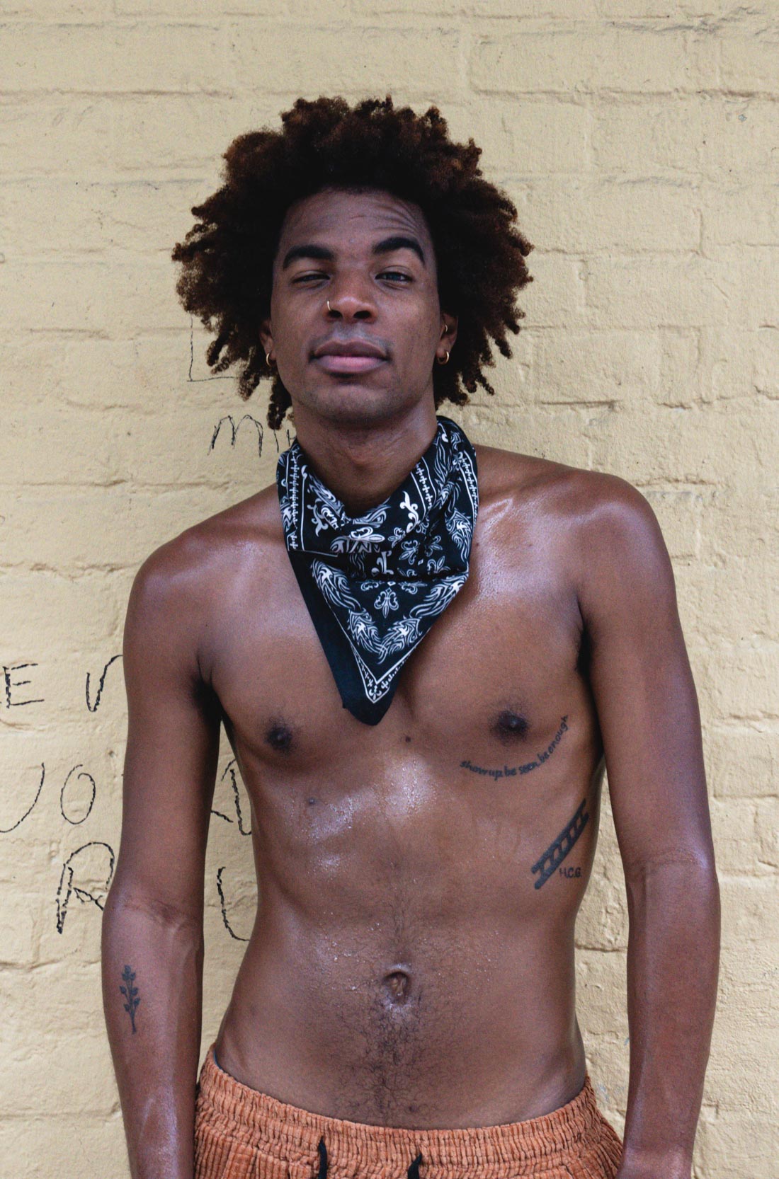 A shirtless man standing and posing on Bourbon Street in New Orleans