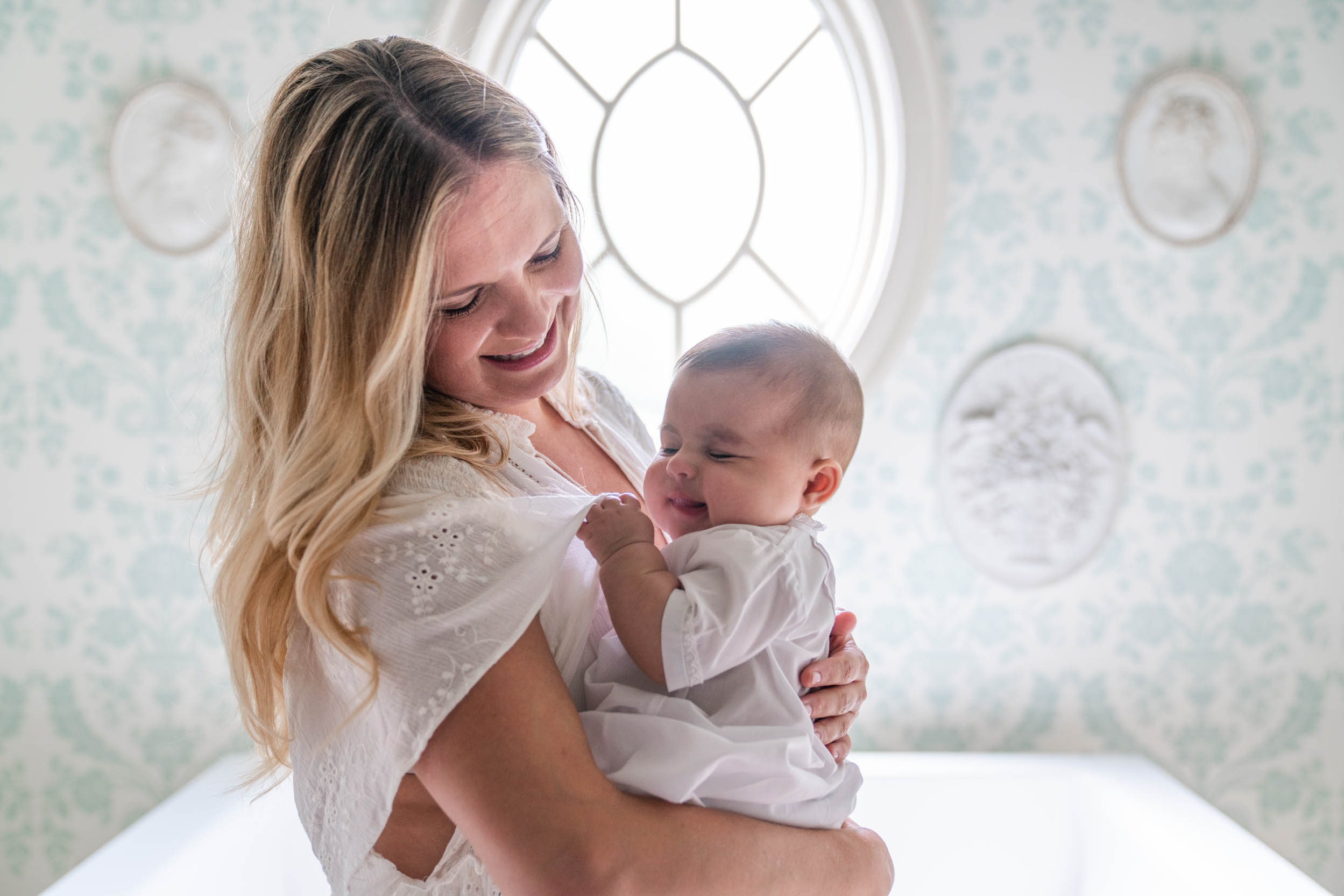 Mother holding baby smiling and laughing for newborn portaits