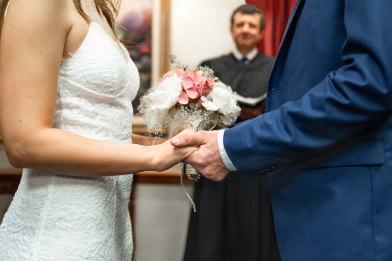 Bride and groom saying vows and holding hands on their wedding day