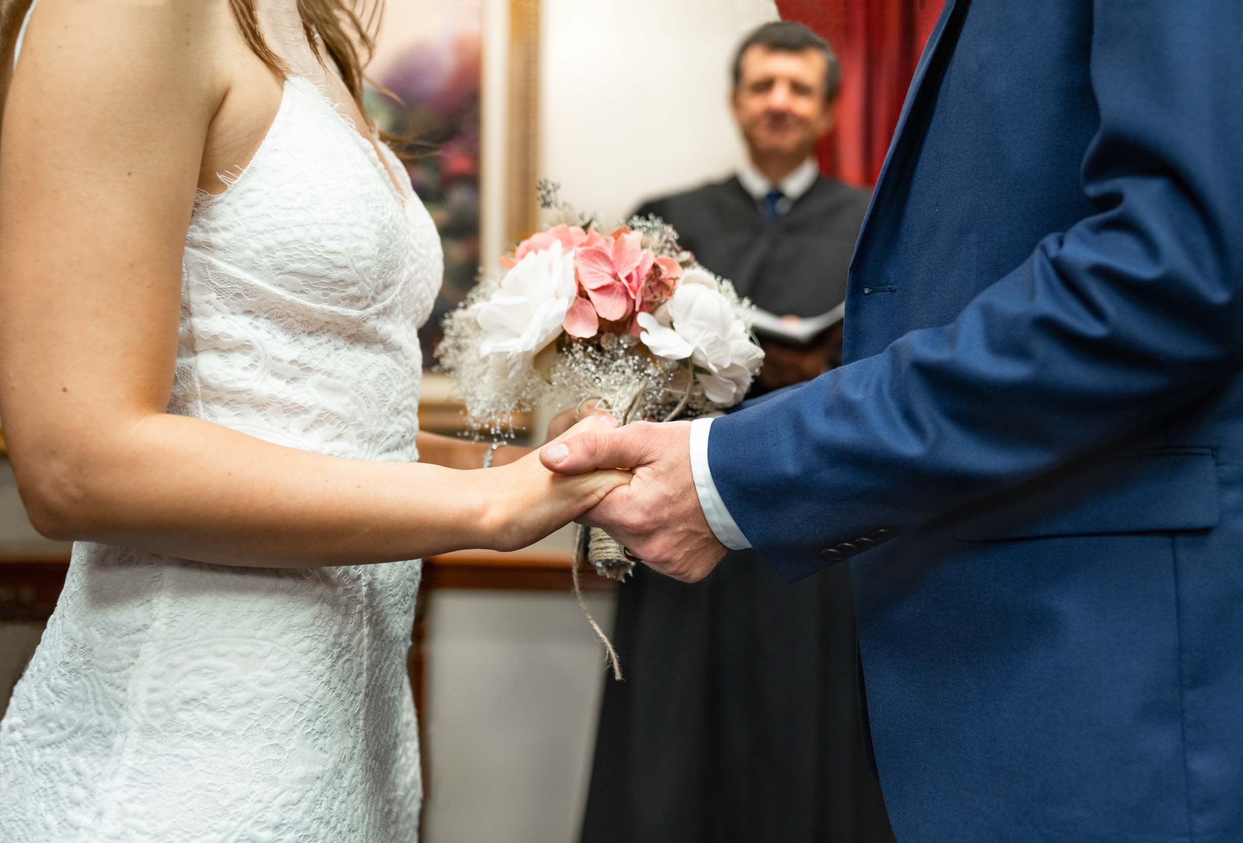 Bride and groom saying vows and holding hands on their wedding day