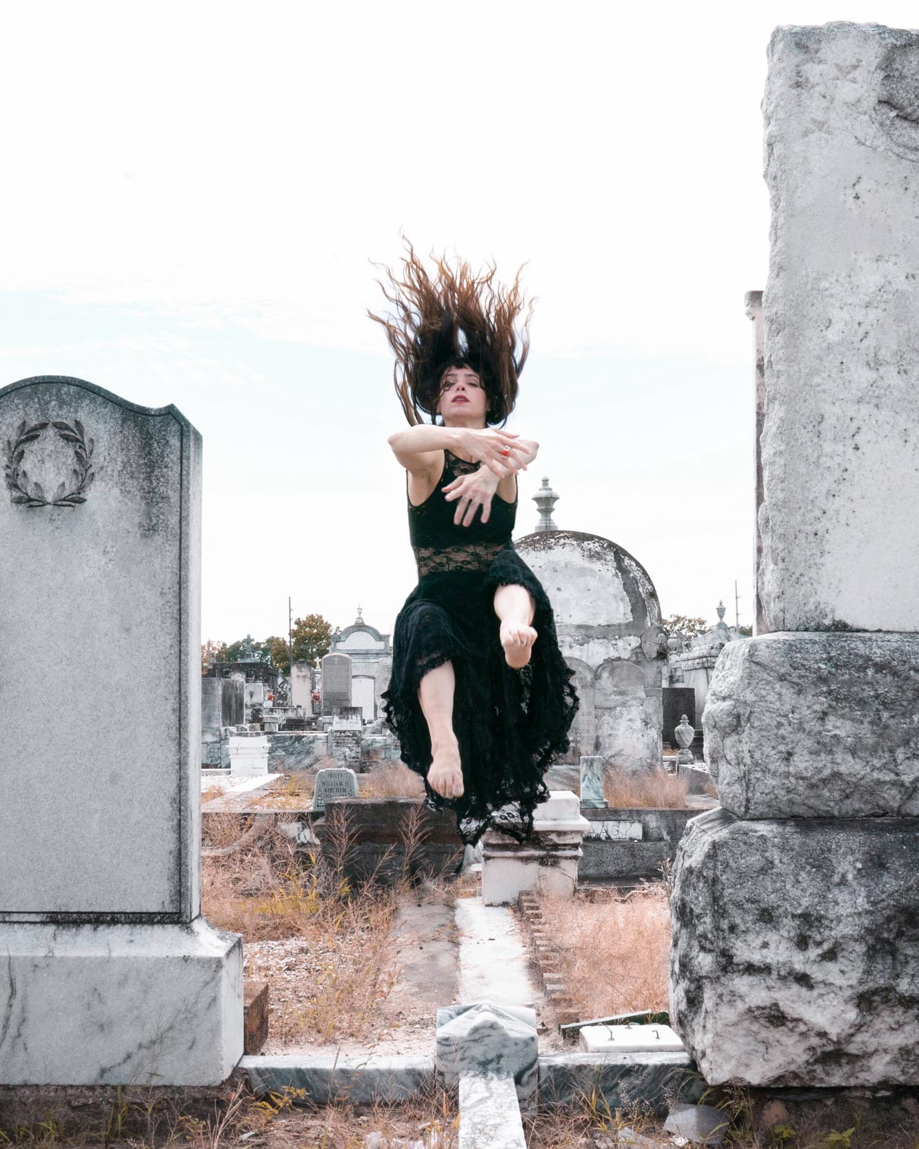 Woman performing epic dance in New Orleans cemetery with her hair flipped back