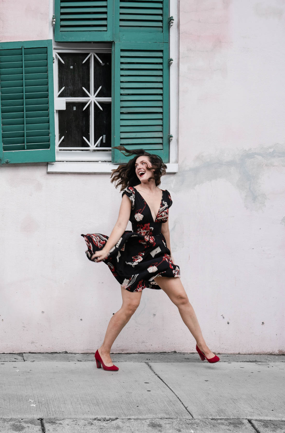 A woman in a beautiful dress running and laughing in the New Orleans French Quarter