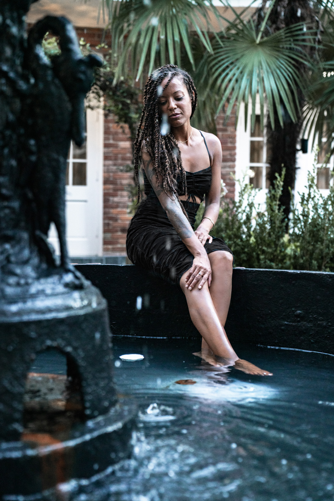 woman modeling in black dress in a fountain in the New Orleans French Quarter