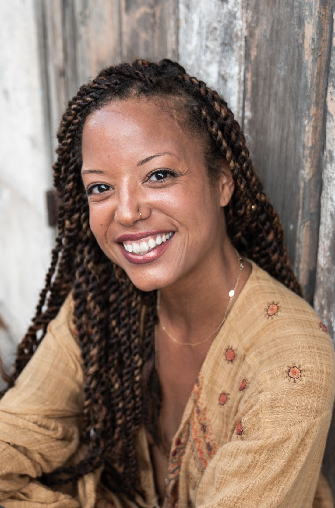 Woman smiling and sitting in front of rustic house in the French Quarter New Orleans