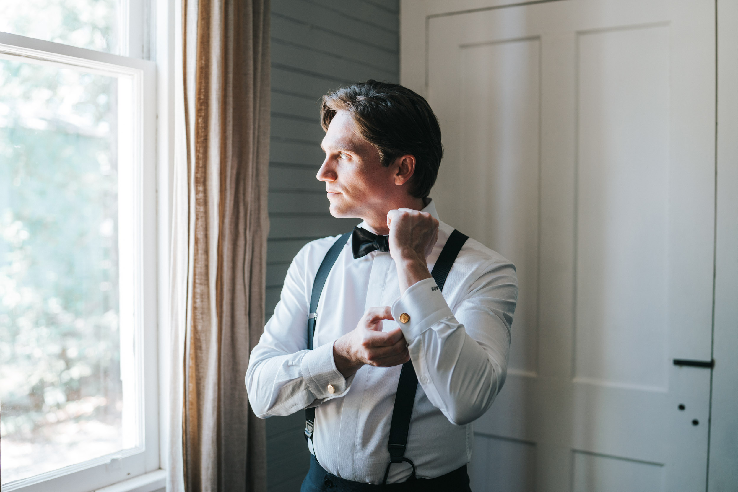 groom getting ready and looking out of the window in Covington, Louisiana