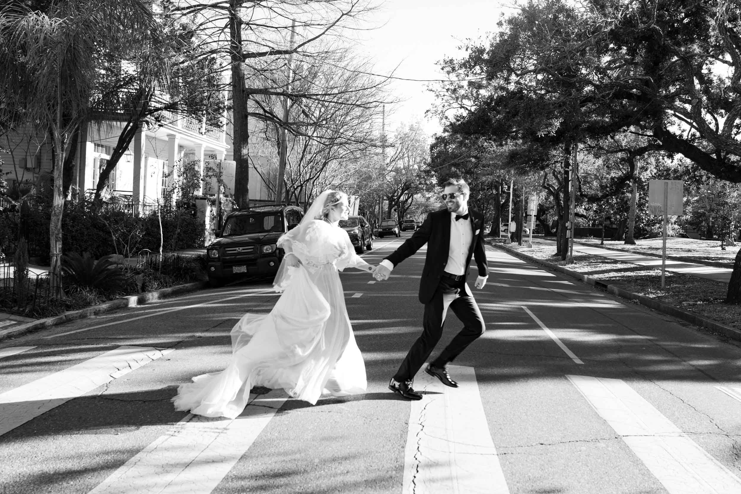 bride and groom running across street in New Orleans on wedding day, inspired by The Beatles Abby Road