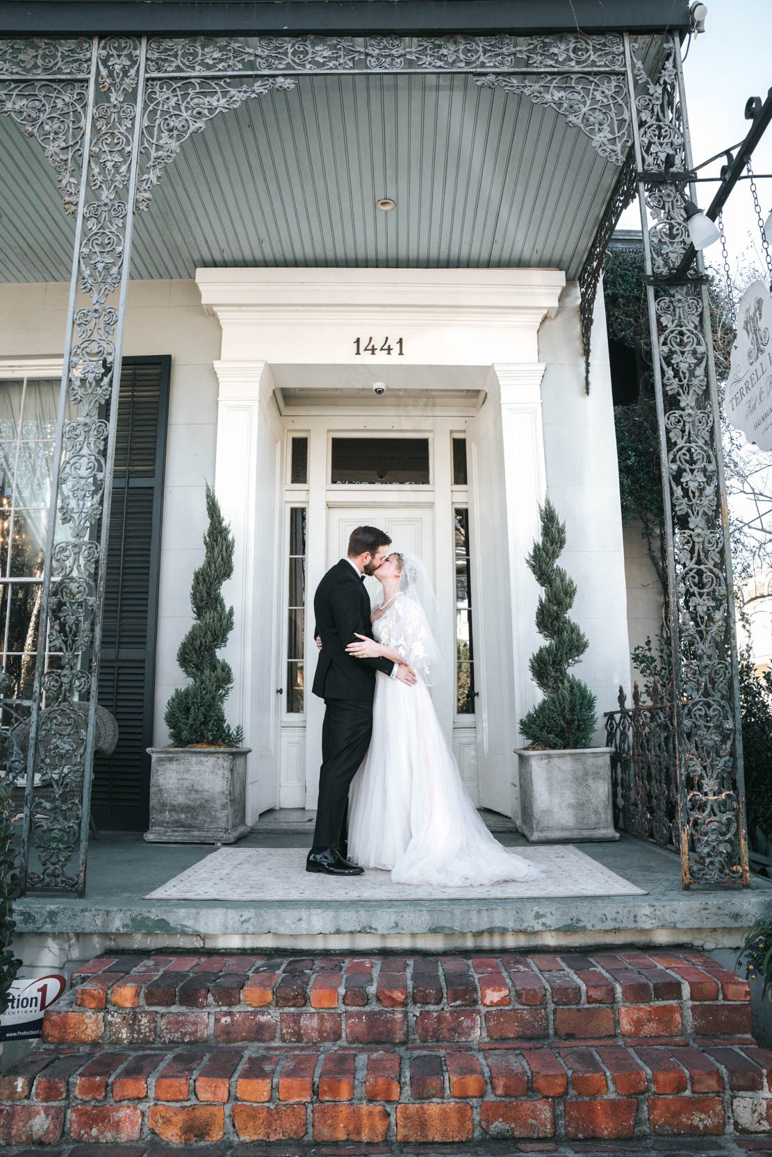 bride and groom kissing in front of Tourelle House in Garden District of New Orleans