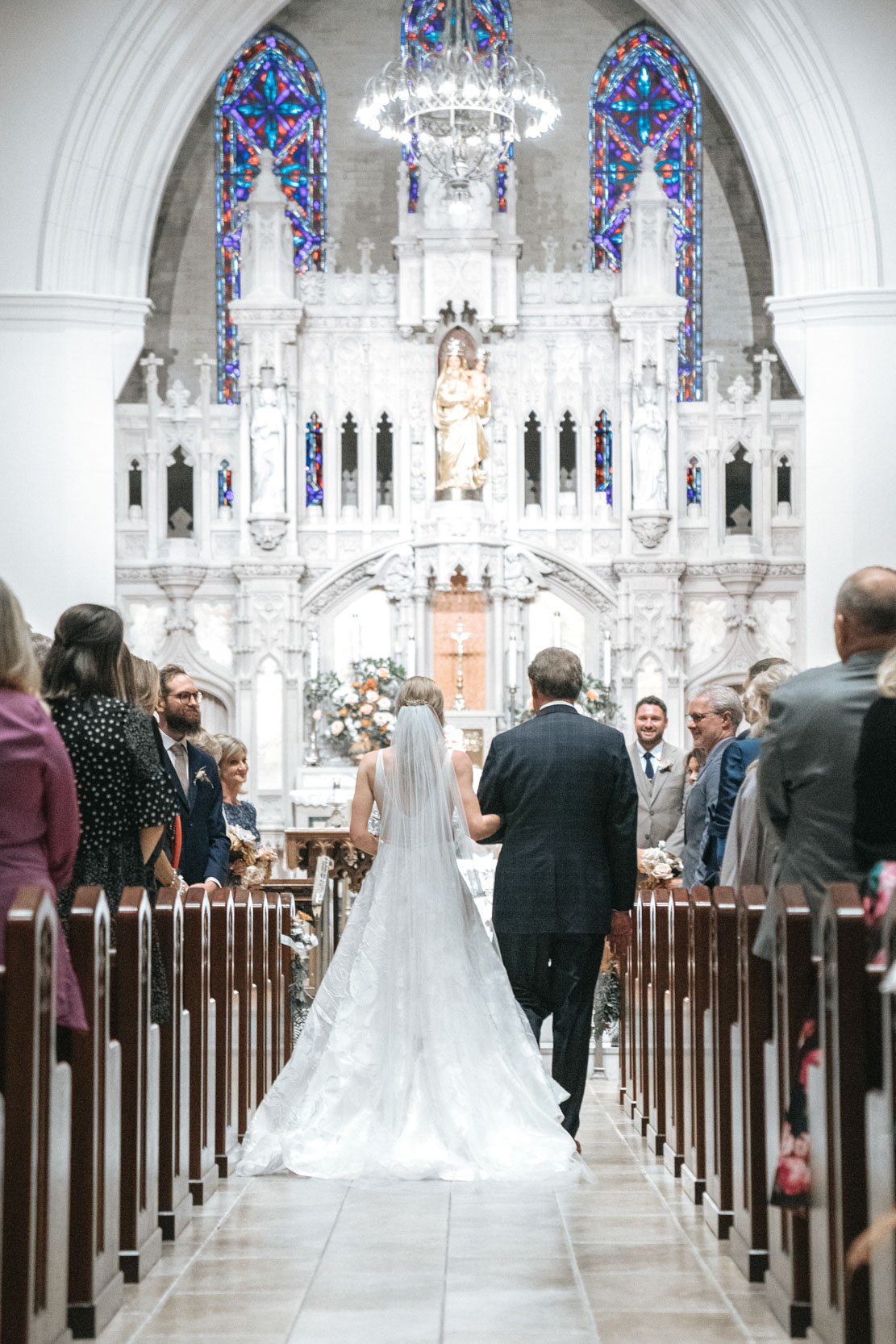 bride and father walking down aisle at Ursuline church in New Orleans