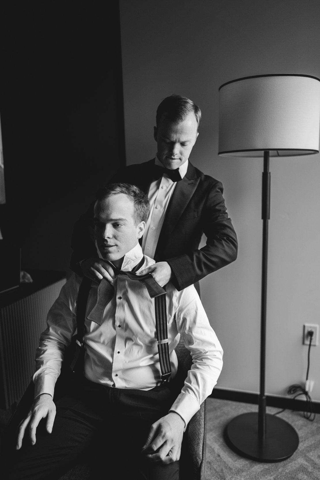 Grooms brother helps groom get dressed at the Hotel Fontenot in New Orleans