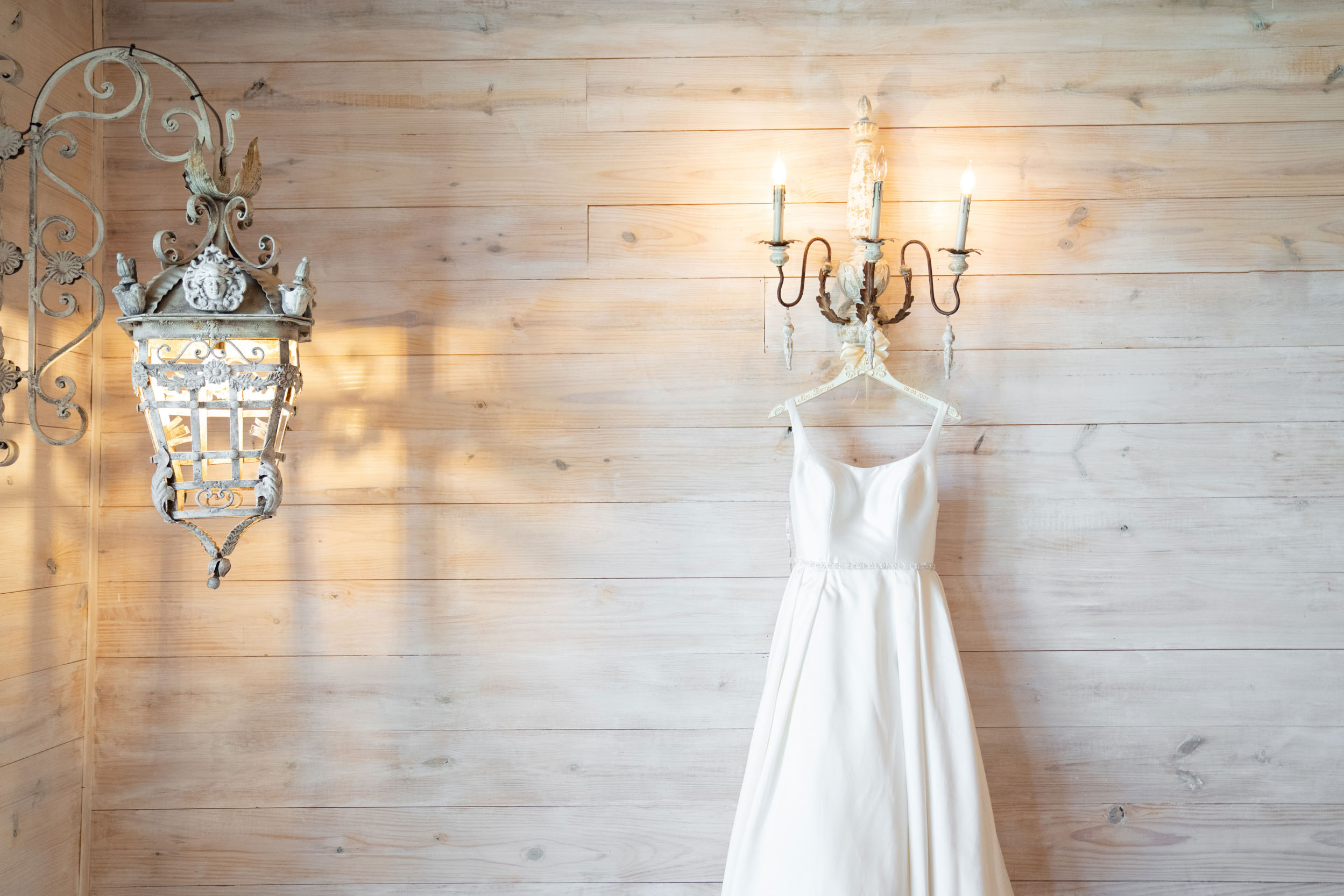 bridal gown hanging on rustic wall at White Magnolia in Louisiana