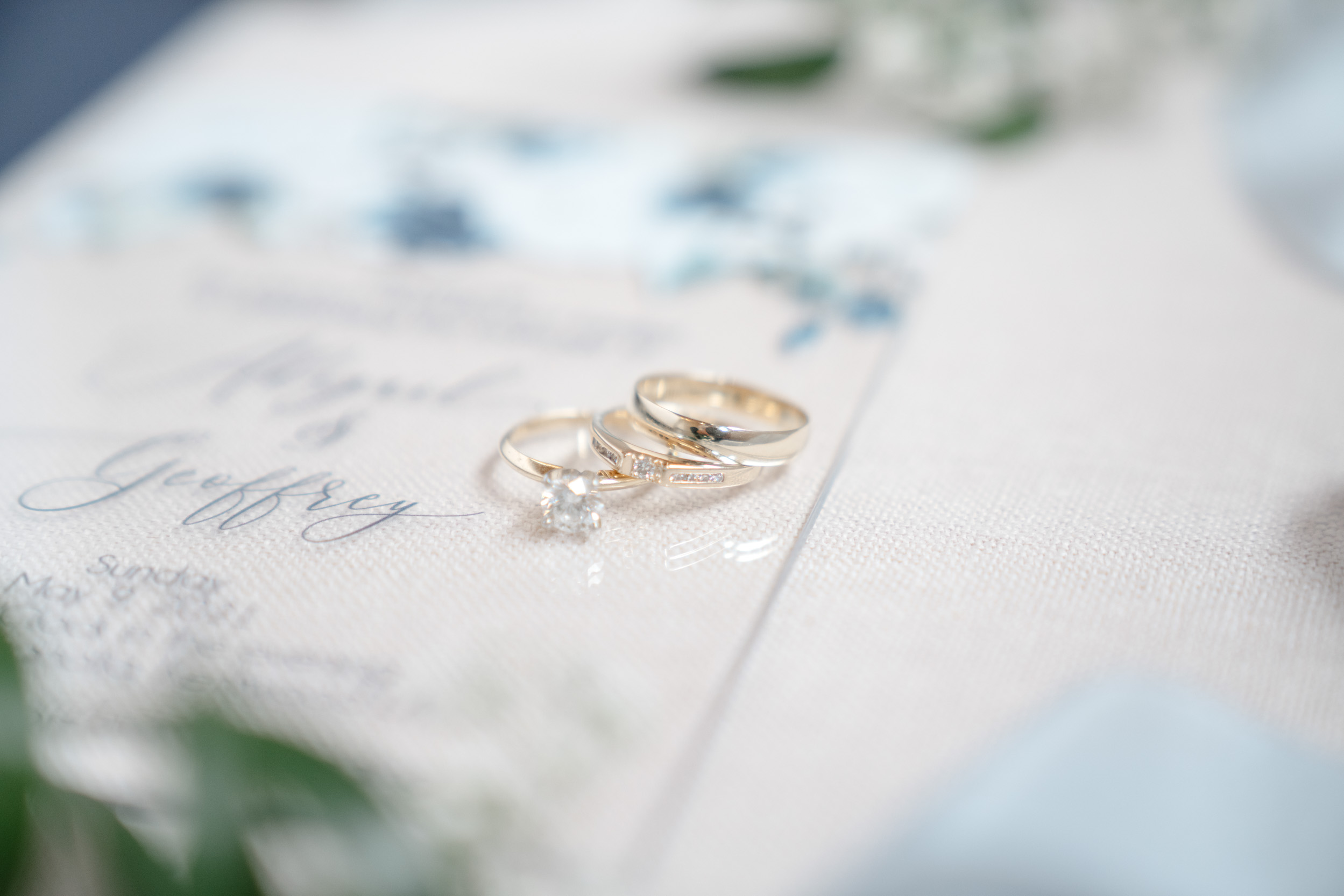 flat lay of wedding rings and invitation