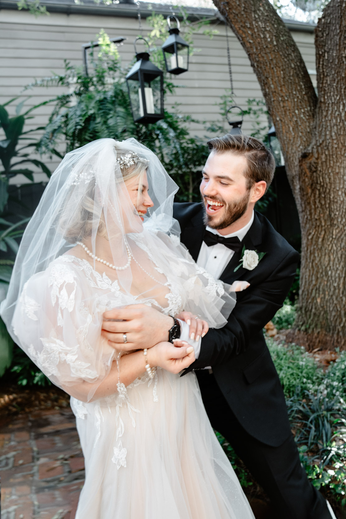 bride and groom laughing during first look at the Tourelle House in New Orleans