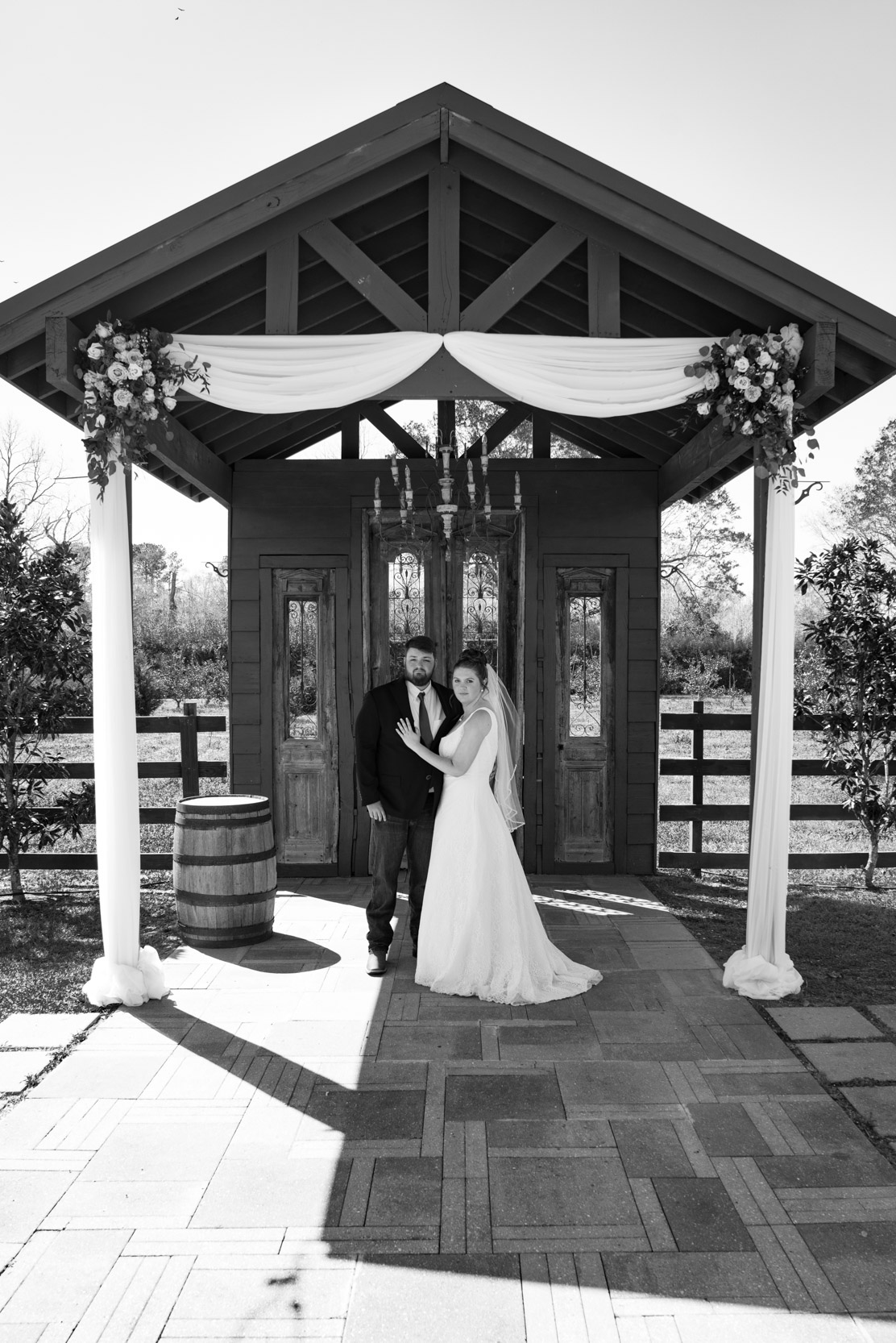 bride and groom under arbor of flowers at the Berry Barn in Louisiana