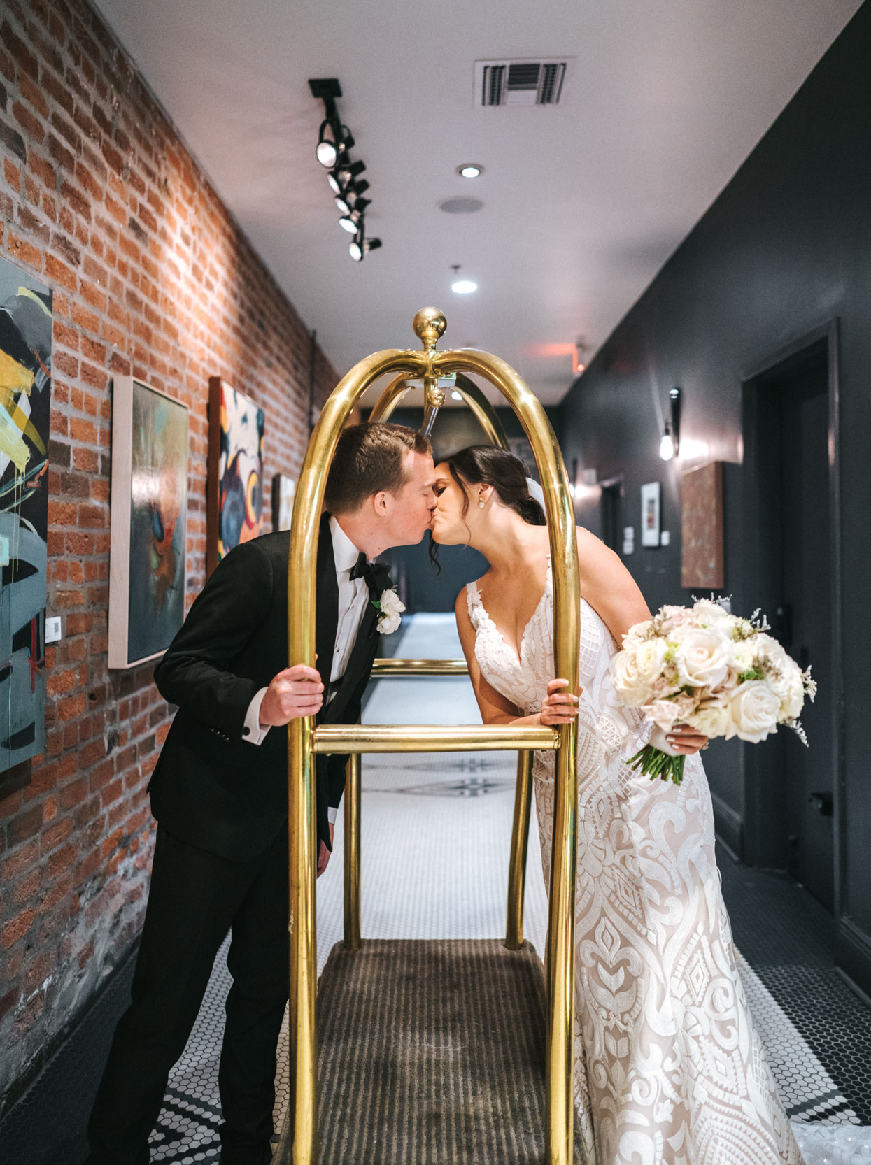Bride and groom kissing over luggage rack at the Old 77 Hotel in New Orleans