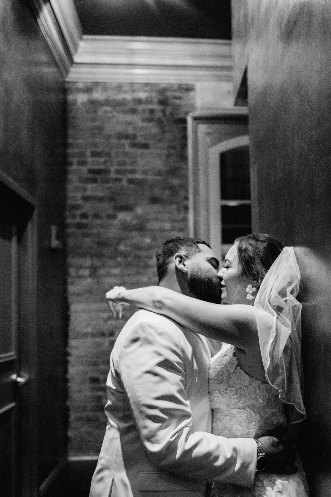 Bride and groom kissing in hallway at Muriel’s Jackson Square in New Orleans
