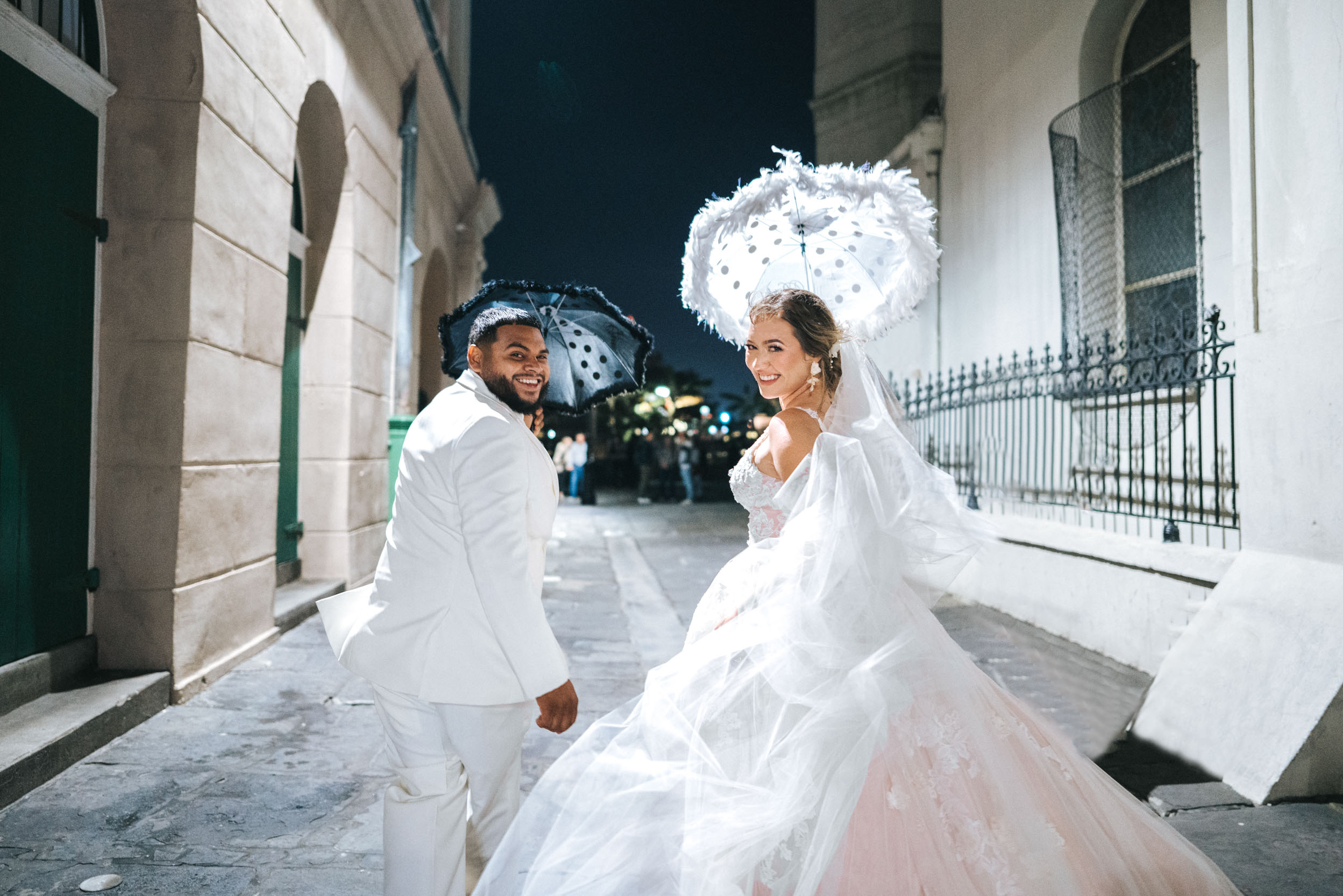 Bride and groom celebrating with their umberllas in French Quarter