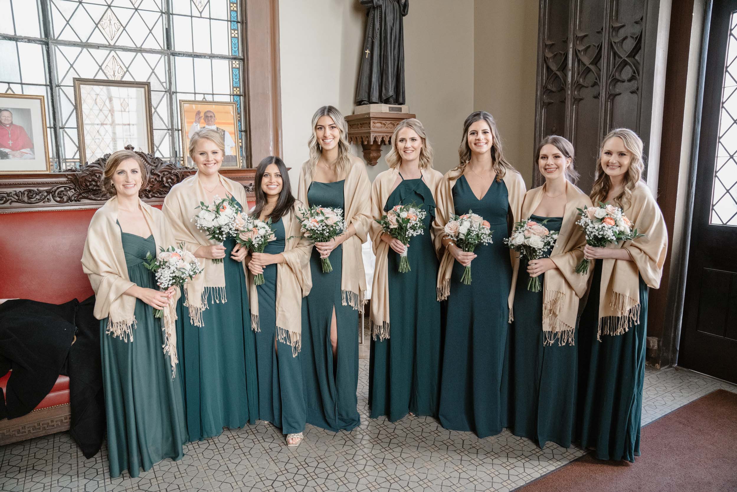 bridemaids holding wedding flowers and smiling at Ursuline church in New Orleans