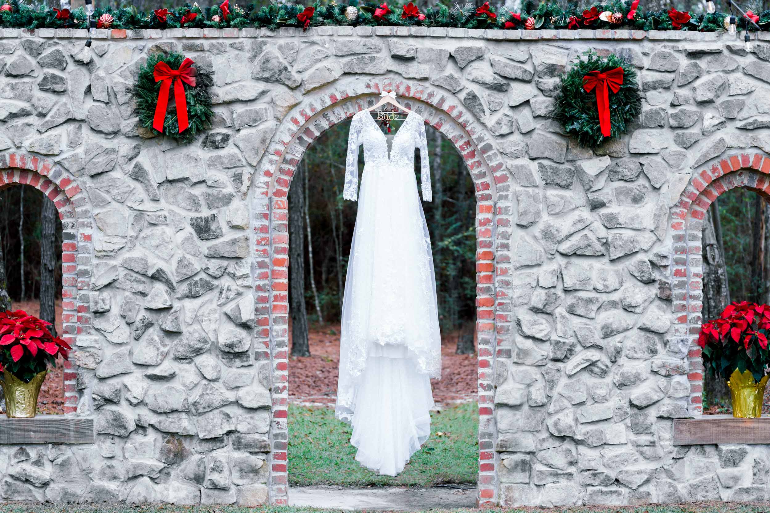 brides dress hanging over stone wall at Creekview Barn in Mississippi