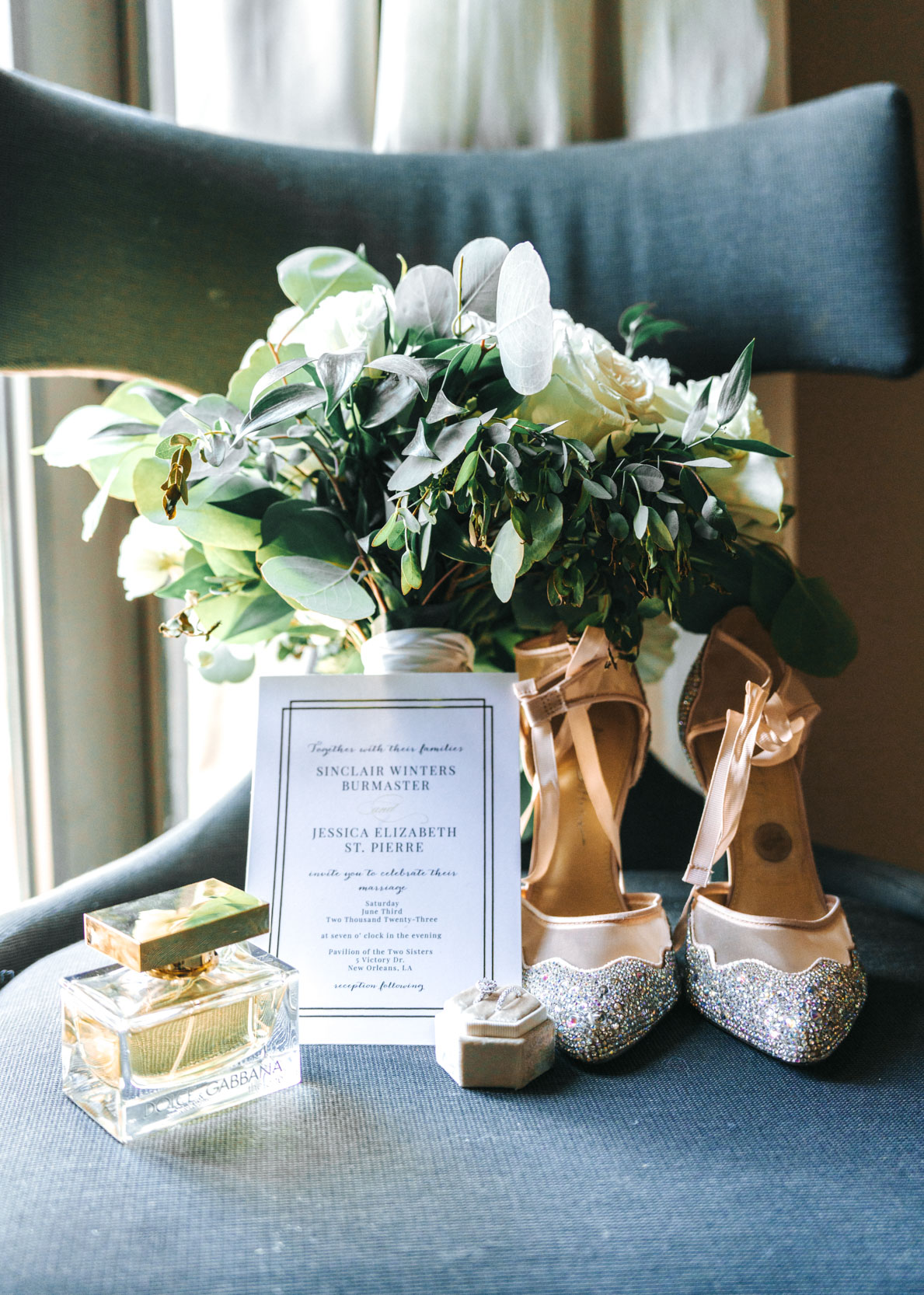 wedding flat lay of bridal shoes, flowers, invitation and perfume
