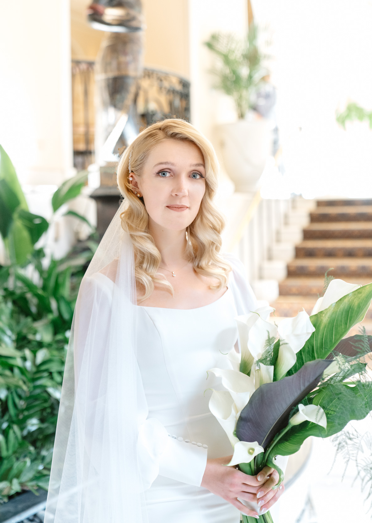 Bride with flower lillies, wedding gown, and veil at the Omni Royal Orleans in New Orleans