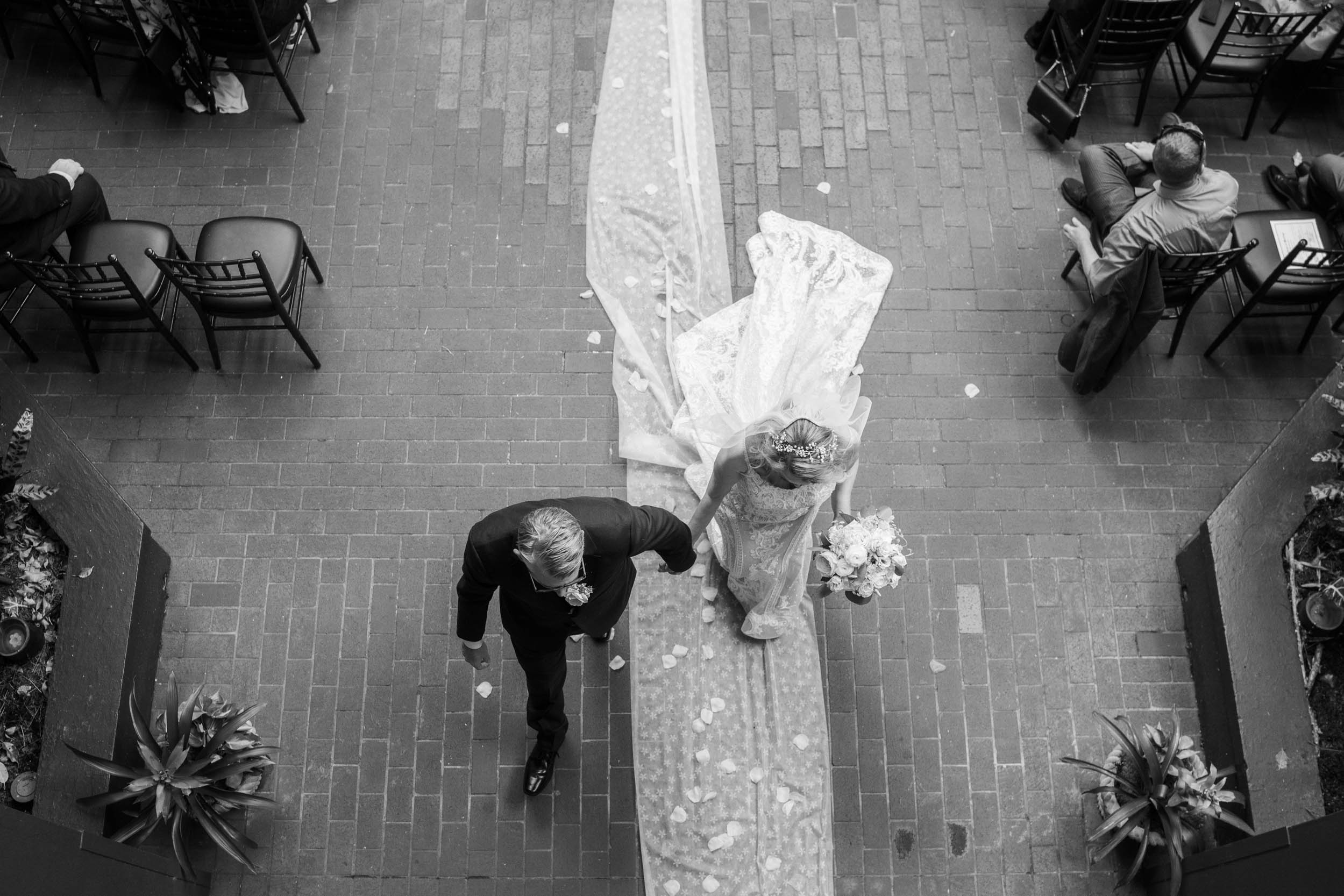 bride and groom exiting wedding ceremony in the courtyard of Hotel Mazarin in The French Quarter of New Orleans