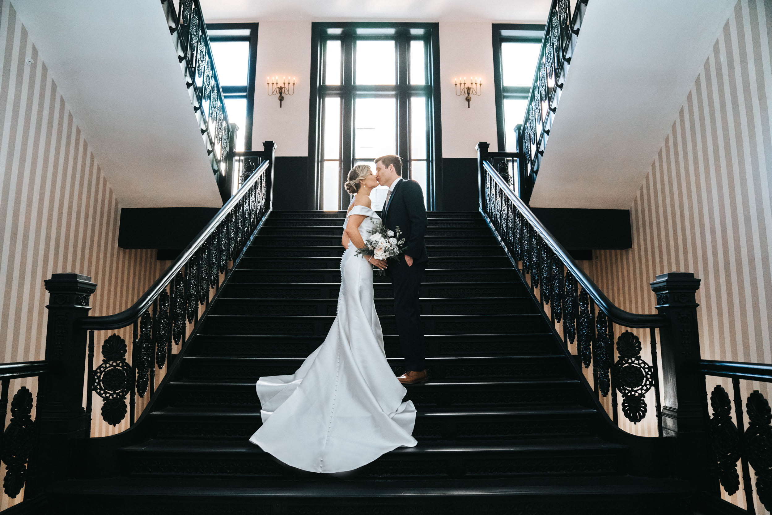 Bride and Groom kissing on antique staircase at the Maison De La Luz Hotel in New Orleans