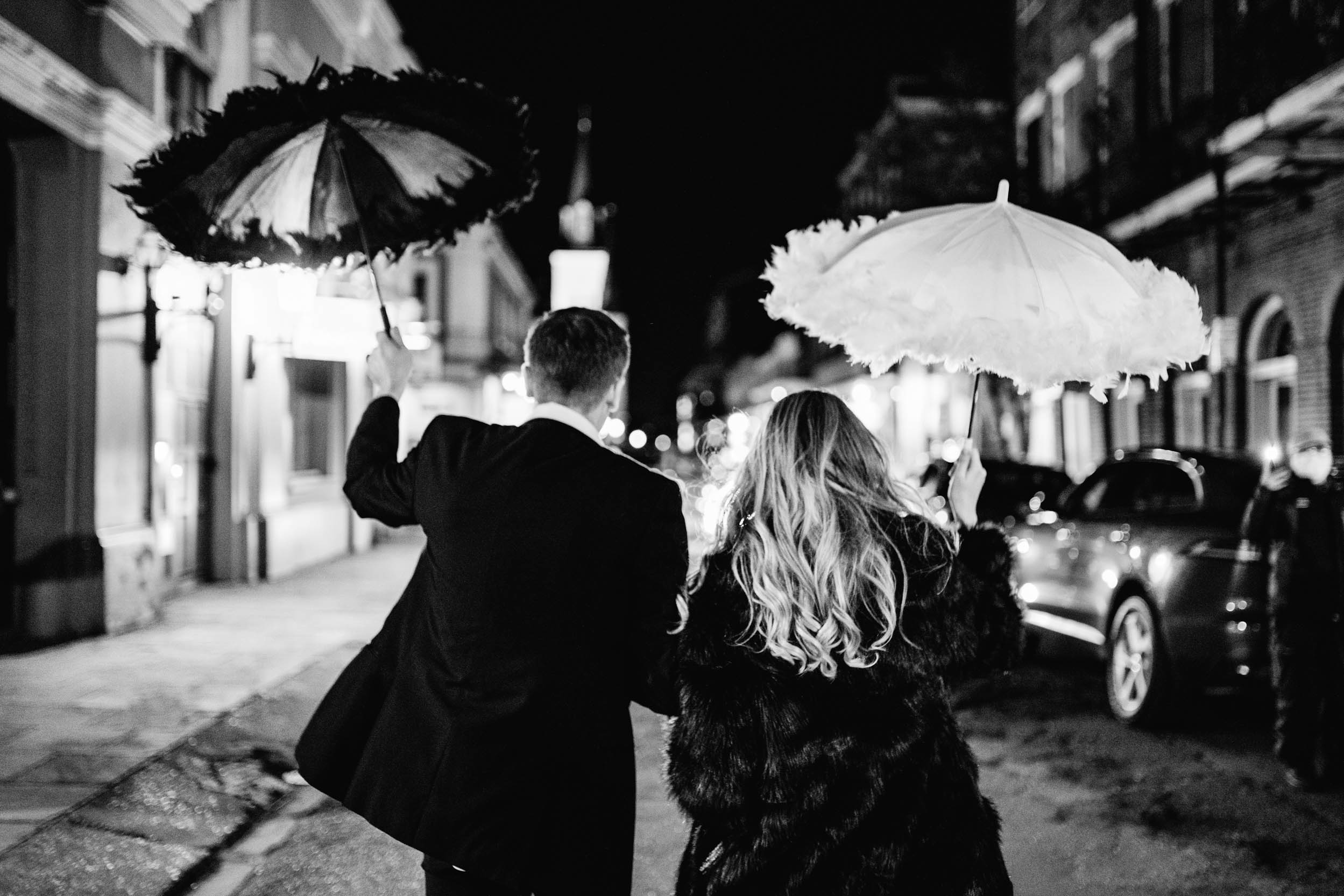 bride and groom celebrating with umbrellas on wedding day in the French Quarter of New Orleans
