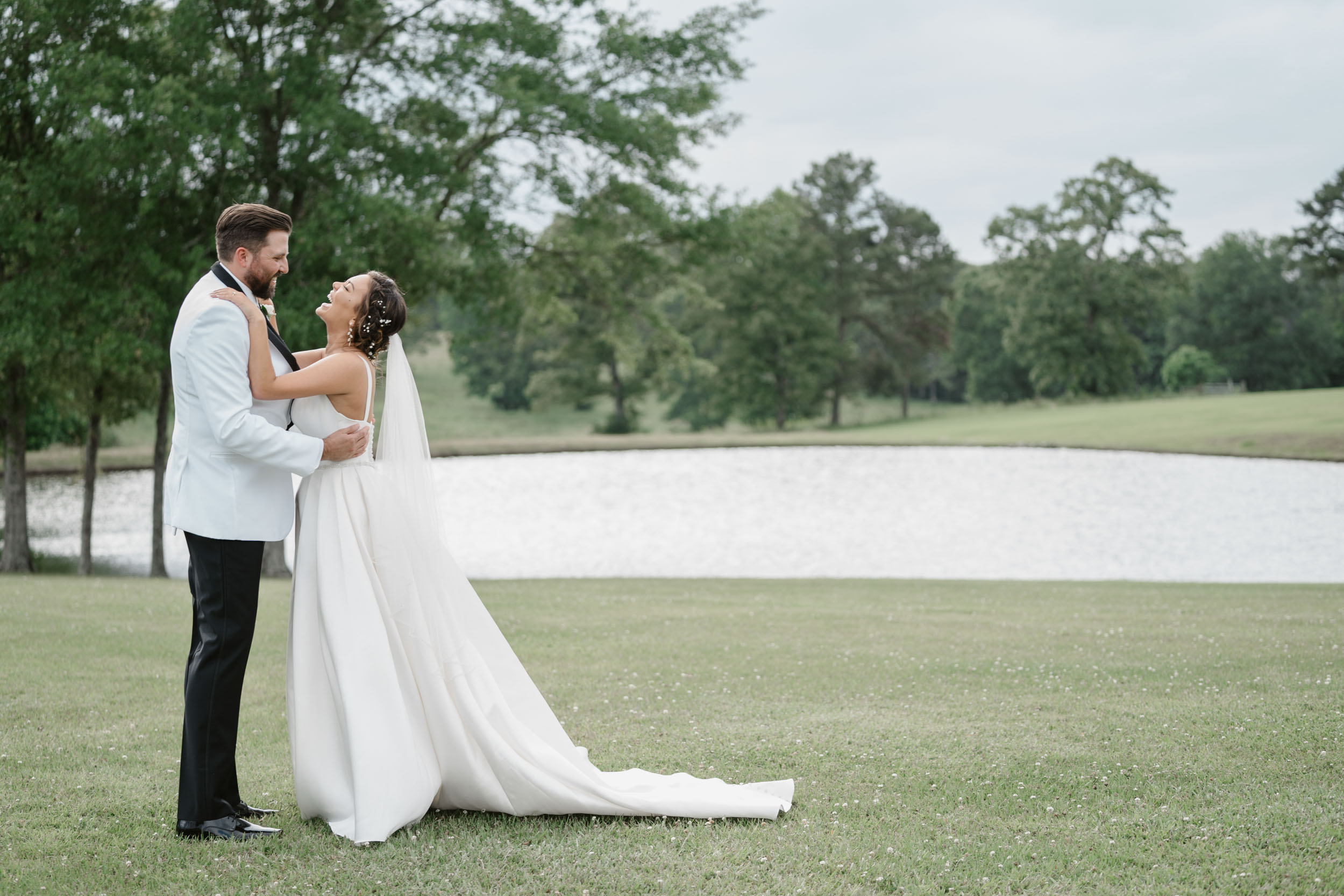 bride and groom laughing in a field at White Magnolia in Lousiana