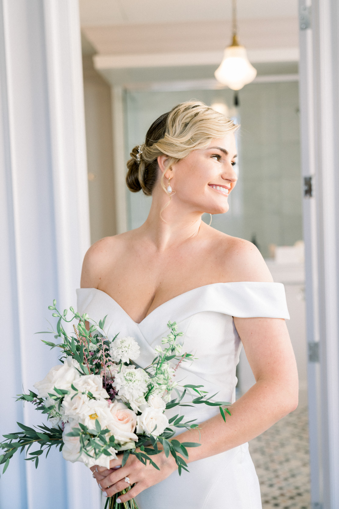 Bride smiling with flowers at the Maison De La Luz Hotel in New Orleans