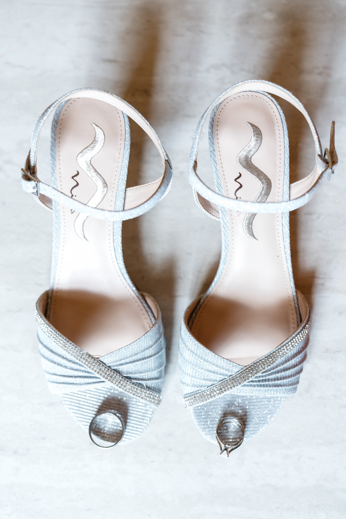 wedding flat lay of bridal shoes and rings