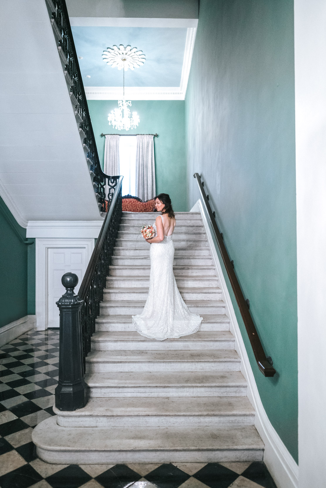 Bride looking back on stair case at Gallier Hall in New Orleans