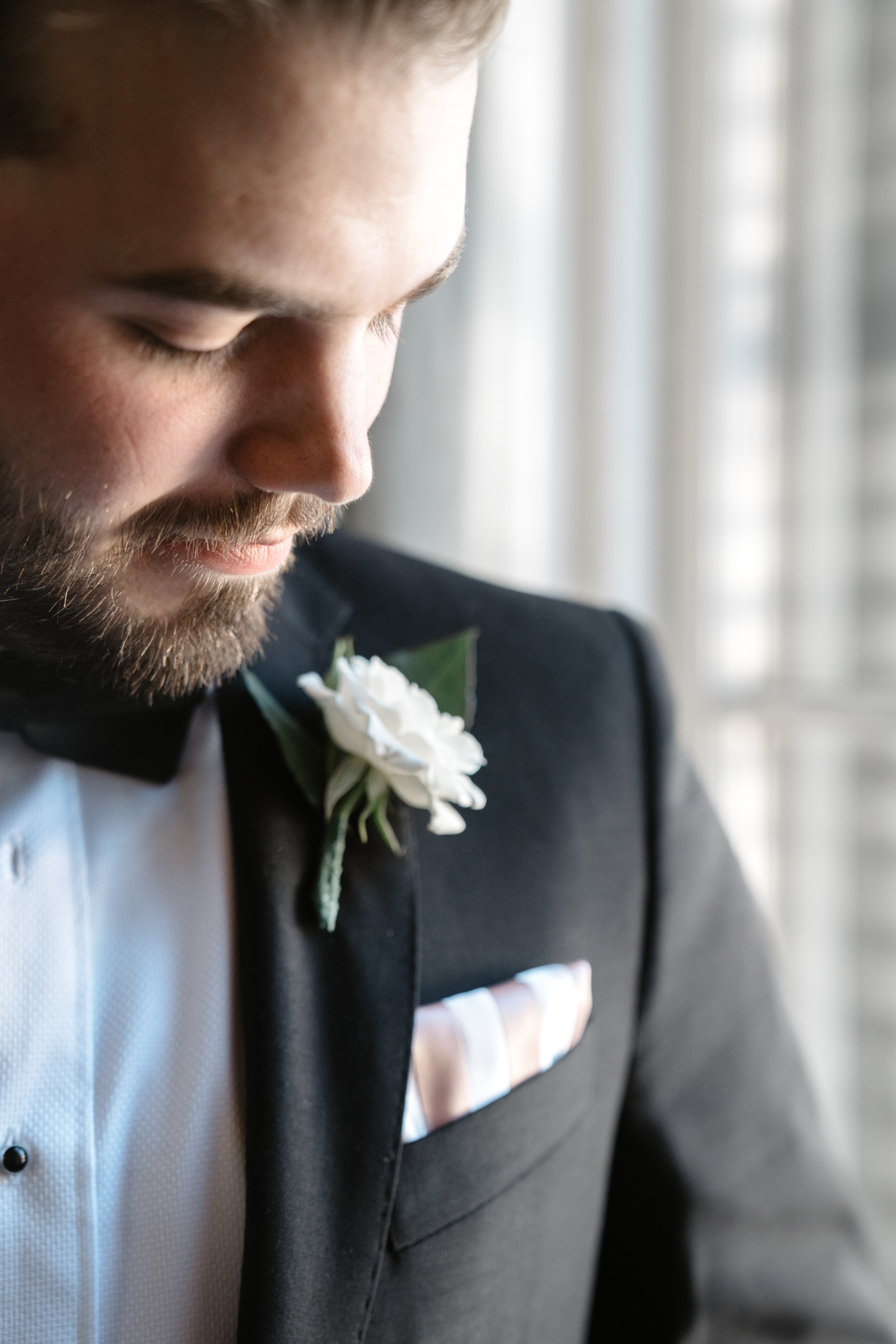 groom looking at his boutonniere at The Tourelle House in New Orleans